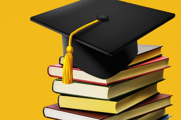 grad cap on pile of books