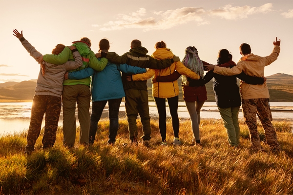 group of people facing sunrise