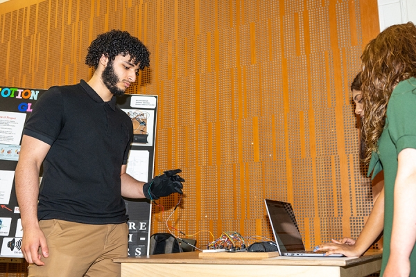 student dons a glove wired to a computer