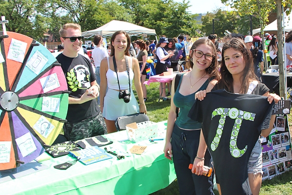 student holding T-shirt she won in a roulette game at Involvement Fair