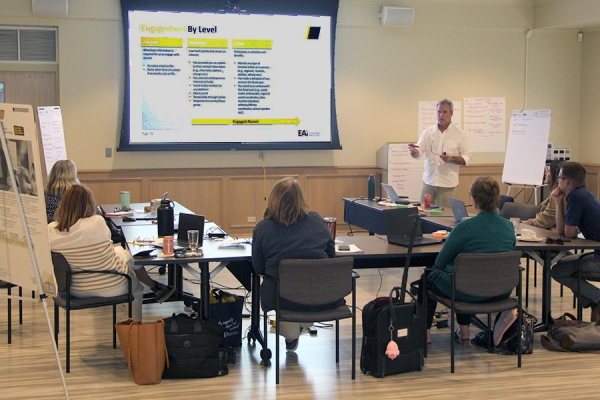 man standing at slideshow screen leading workshop