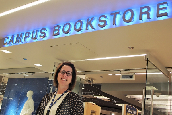 Marianne Nitz posing before Campus Bookstore sign