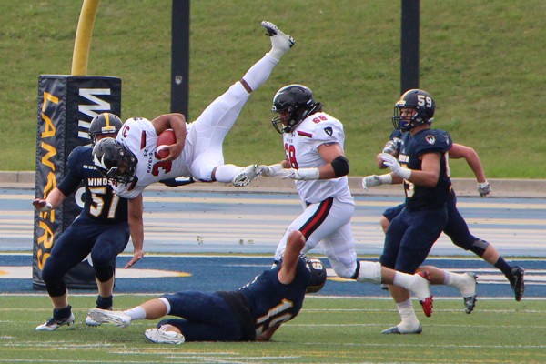 Windsor defensive back Dan Stirling upends Carleton running back Nathan Carter in play during the Labour Day Classic, Monday on Alumni Field.