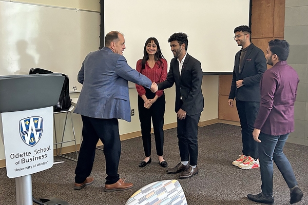 Alan Drouillard congratulates Binny Kaur, Rohith Mahadevan, Kalyan Parimi, and Shrirang Shripad Rajguru.