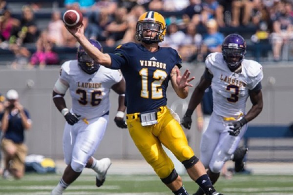 Windsor quarterback Austin Kennedy evades defenders to make the play.