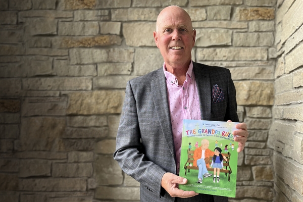 Jim Weese holding his book: The Grandpa Rules: Essential Lessons for Success in Life and Leadership.