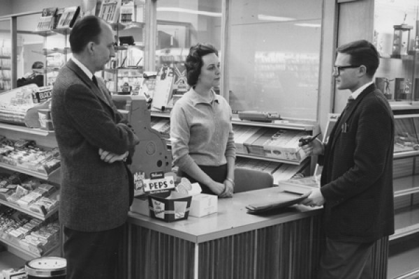 Manager and clerk wait on Bookstore patron.