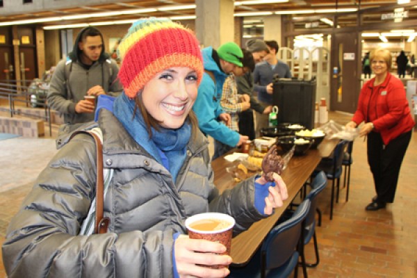 student holding coffee and cookie