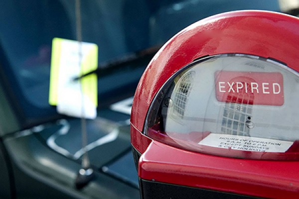 meter reading &quot;expired&quot; car behind with ticket on windshield