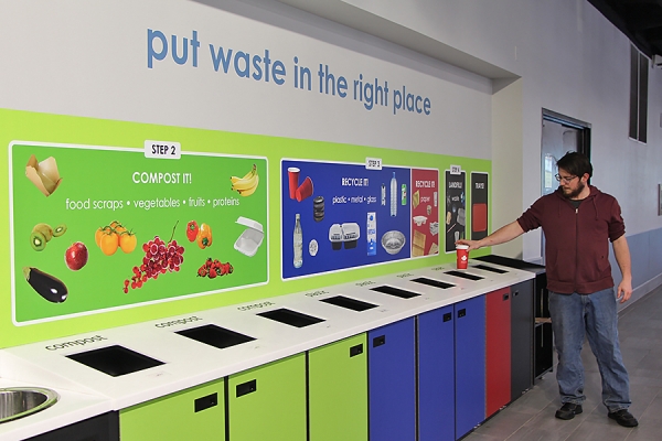 Josh Davis throws paper cup in paper recycling bin