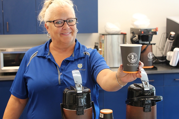 server holding out coffee cup