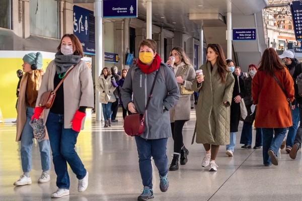 People walking in mall, some with masks and some barefaced