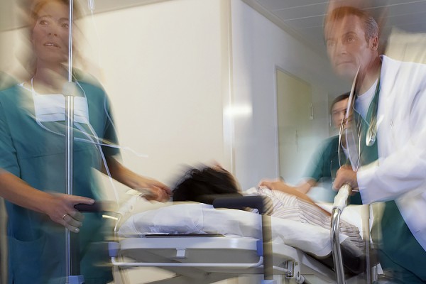 Doctor and nurse escorting hospital patient through hallway