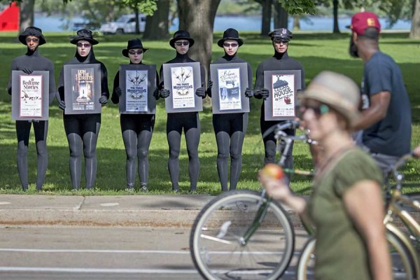 Members of the University Players hold posters advertising its productions.