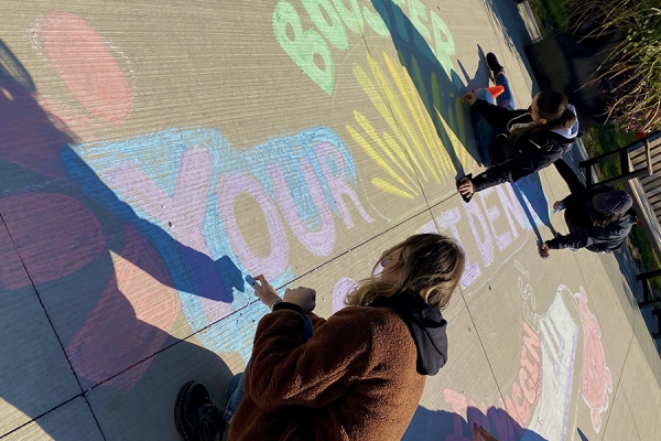 students drawing on sidewalk with chalk