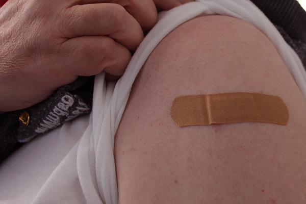 arm bearing bandage on vaccine site