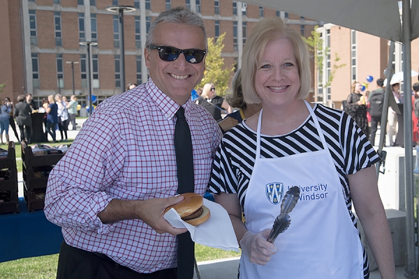 university president and dean serving hamburgers