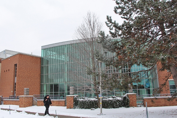 exterior of CAW Student Centre young woman walking by