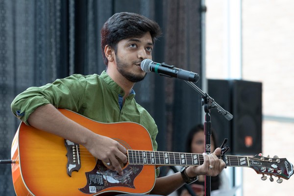 man strumming guitar onstage