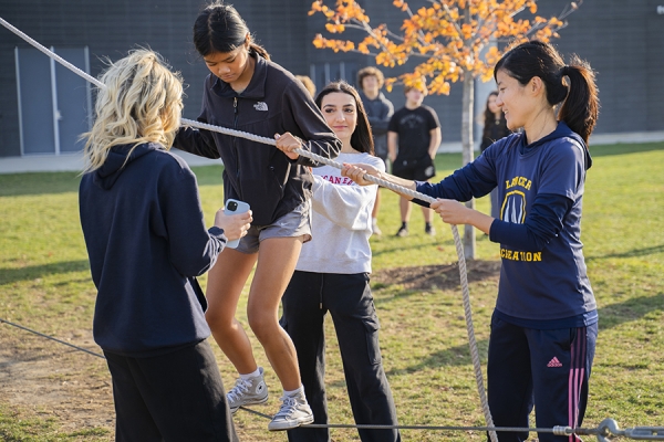 Ella Zhang lends a helping hand to students walking tightrope