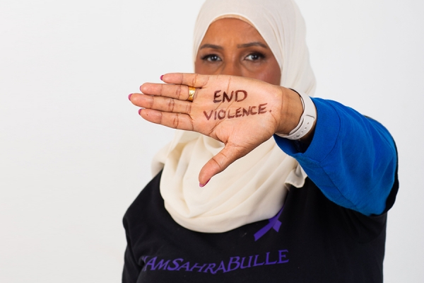 woman holding up hand hennaed to read end violence