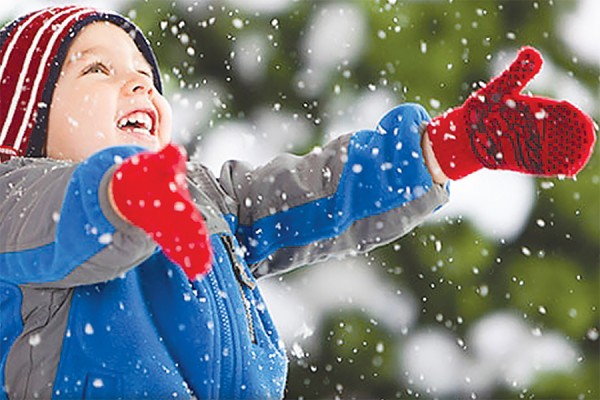 small boy in snow wearing parka, hat and mitts