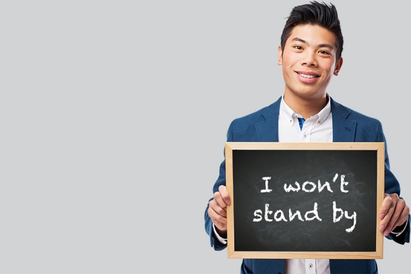 man holding sign &quot;I won&#039;t stand by&quot;