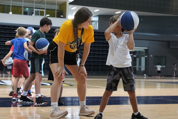 student counsellor leading youth basketball camp