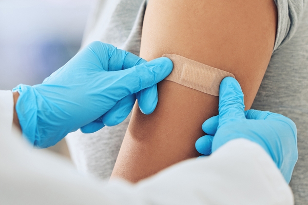 bandage being applied to arm at site of flu shot