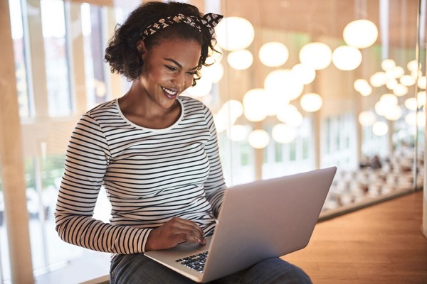 Young person smiling at laptop