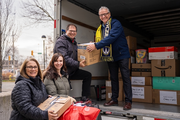 Rob Gordon takes boxes from volunteers Katherine Simon, Sabina Howell, and Chris Knack