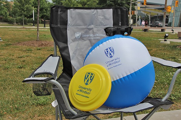 sunglasses, a toy flying disk, and an inflatable beachball balanced on folding lawn chair