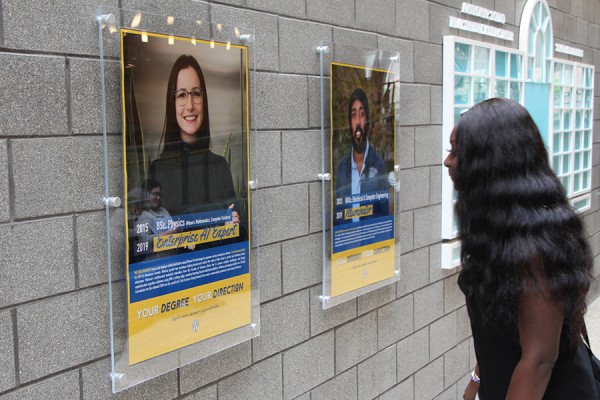 Esther Anim looks at some of the posters of alumni on display in the Toldo Health Education Centre.