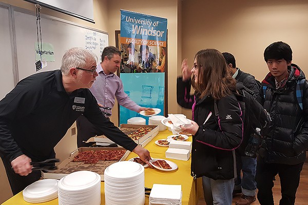 Phil Dutton and Charles Macdonald serve pizza