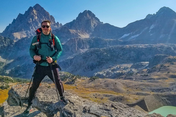 Camilo Silva standing against background of Teton mountains