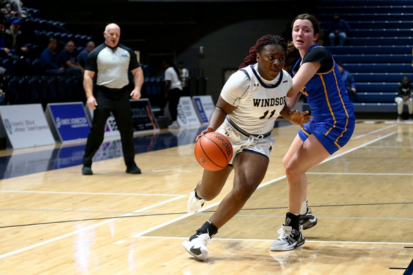 basketball player dribbles past an opponent