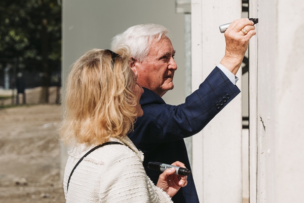 Gail and Don Rodzik sign a concreate wall panel