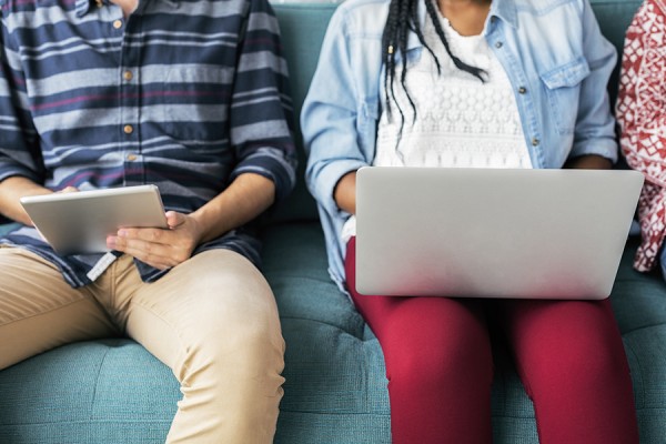 students holding laptop computers