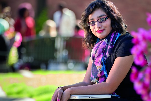 Student sitting on becnh outside law building