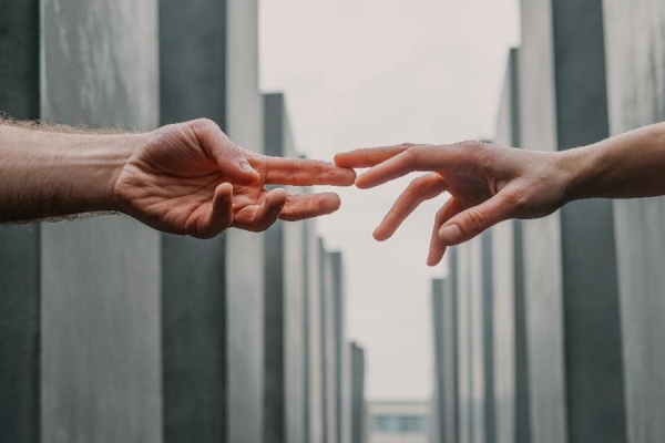 two hands reaching out to touch fingertips