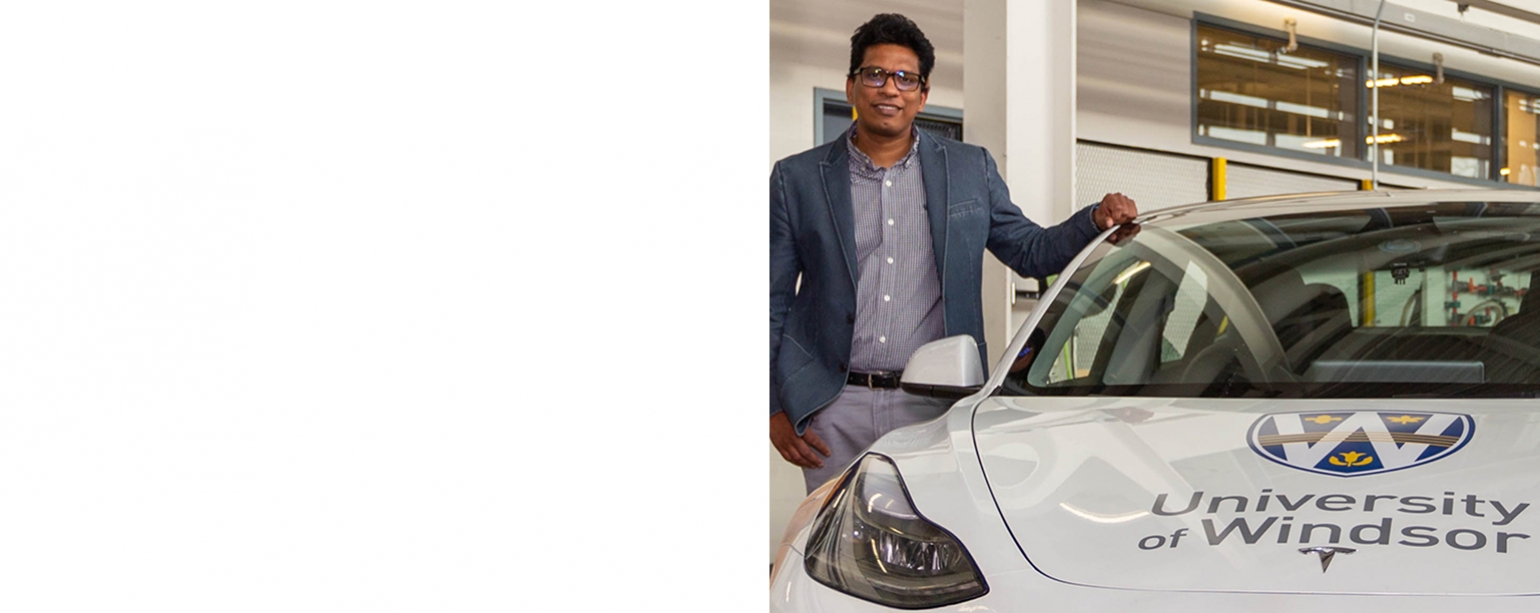 Bala Balasingam posing with electric car