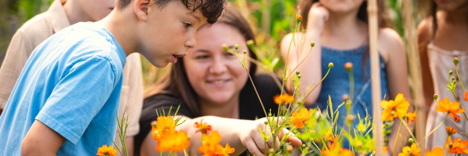 An education student showing young students a community garden