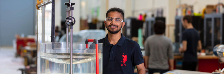 Student standing in lab with water tool working 