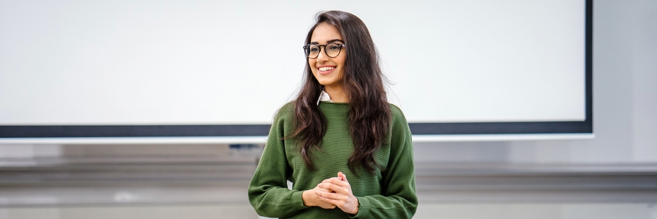 International student standing at front of class giving presentation