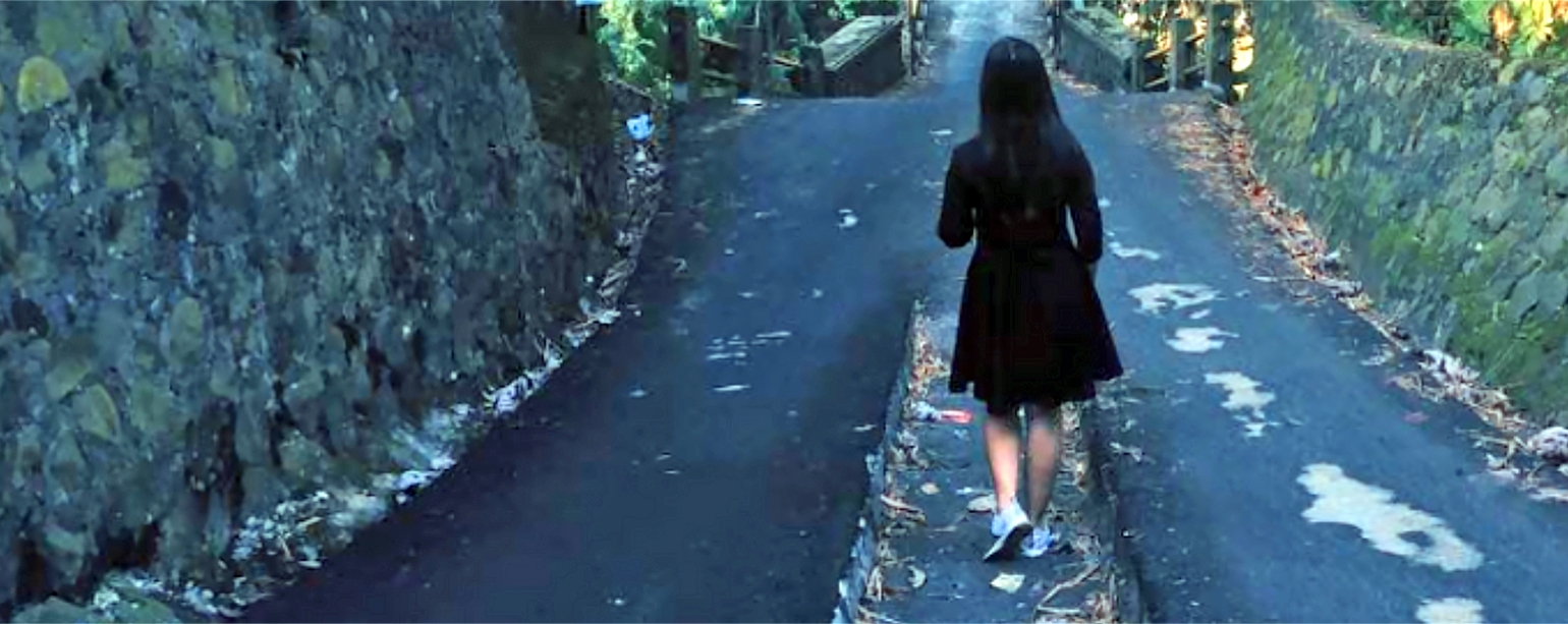 young woman walking to school along rural path