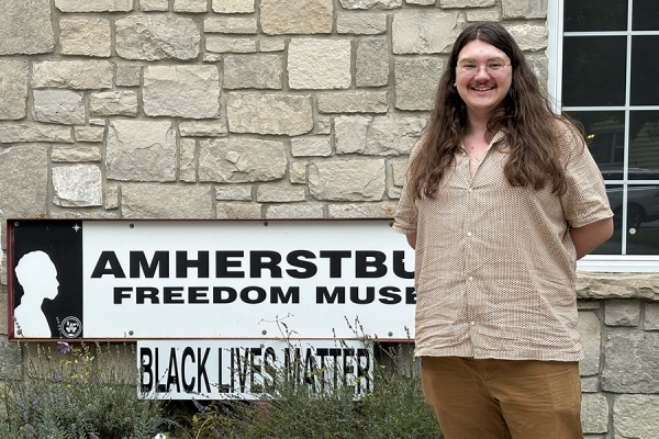 Man with shoulder length hair stands outside the Amherstburg Freedom Museum