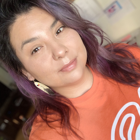 Headshot of Esentsei Staats-Pangowish wearing an Orange Shirt Day t-shirt 