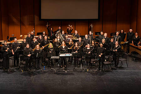 Members of the Fall 2022 University Wind Ensemble pose on the Capitol Theatre stage