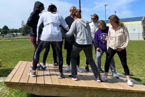 Participants balancing on a wooden beam.