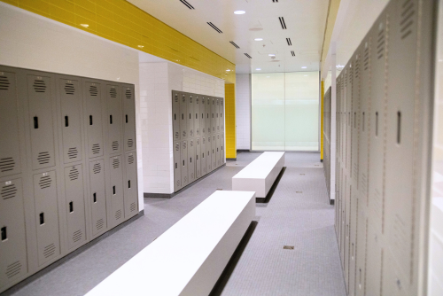 Change room with lockers and yellow tile.